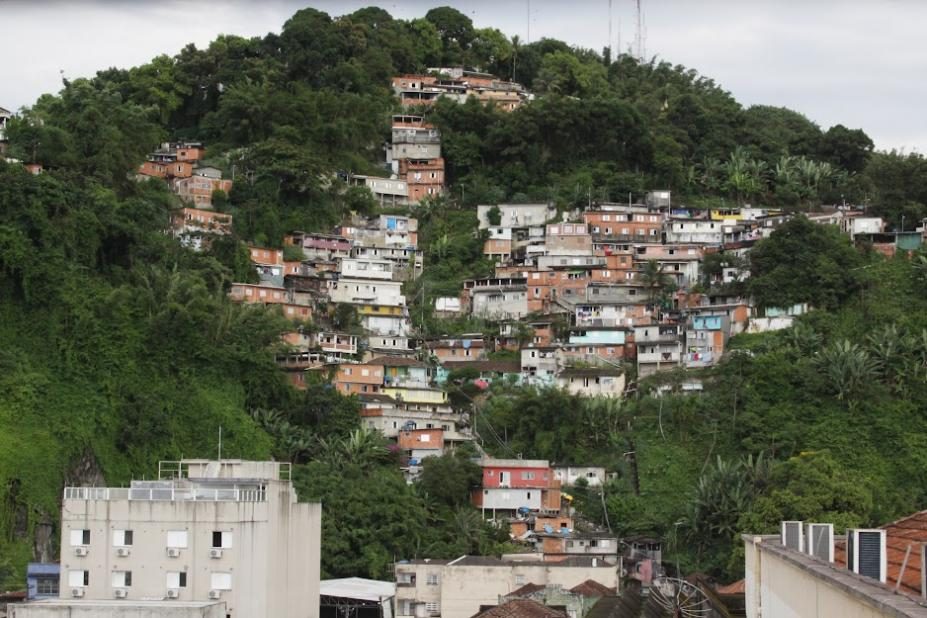 Casas construídas em uma encosta íngreme, ilustrando o tipo de moradia mais vulnerável a sinais de instabilidade do solo.